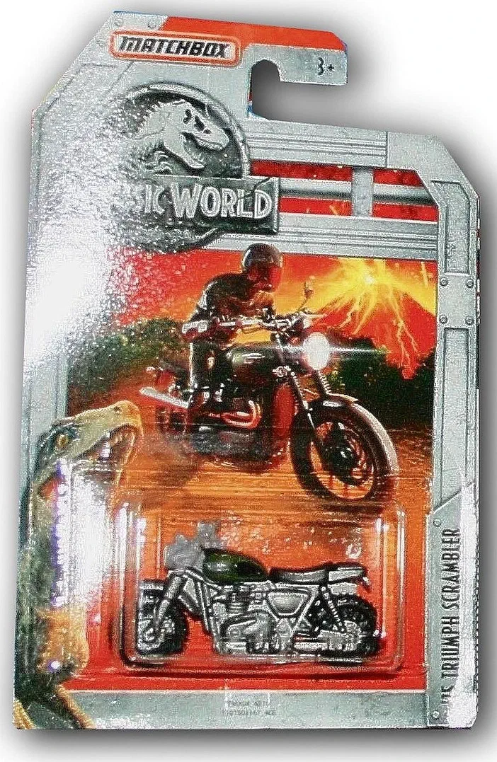 Packaging Matchbox de la Triumph Scrambler (Jurassic World) avec un motard et des dinosaures en arrière-plan