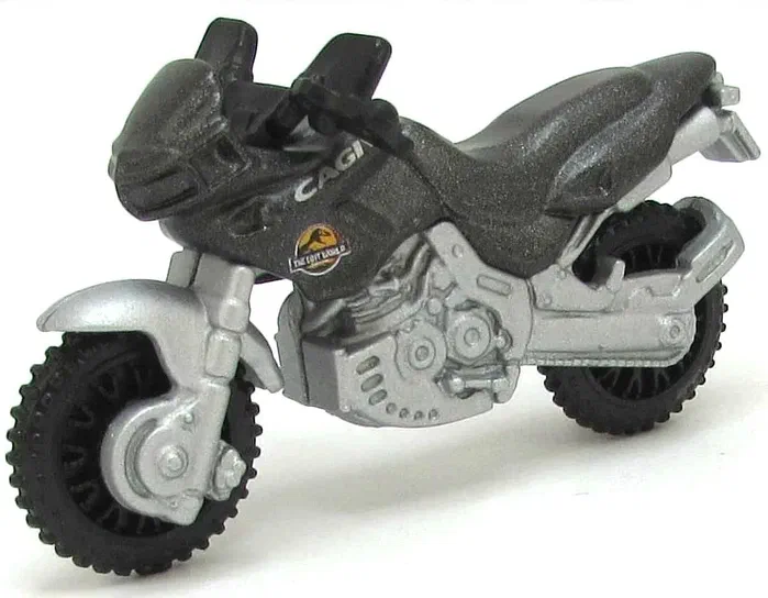 Petite moto Matchbox Cagiva Canyon 500 de couleur gris métallisé avec des pneus noirs et un logo Jurassic Park sur le réservoir.