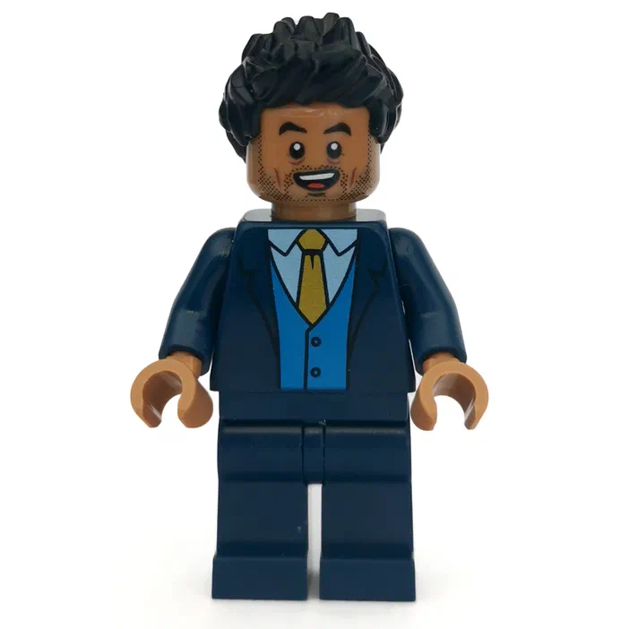 Minifigurine de Simon Masrani dans un costume bleu foncé avec une cravate jaune et des cheveux noirs bouclés.
