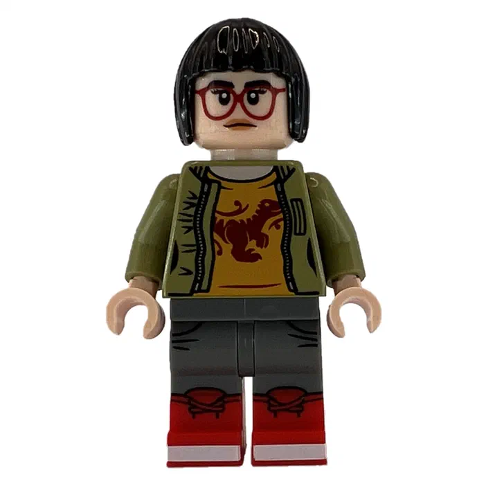 Minifigurine LEGO Zia Rodriguez avec des cheveux noirs, des lunettes rouges et un t-shirt jaune à motif dinosaure.